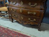 une commode en bois et une chaise dans une pièce