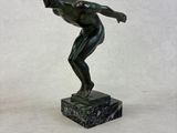 a statue of a man throwing a frisbee on a marble base