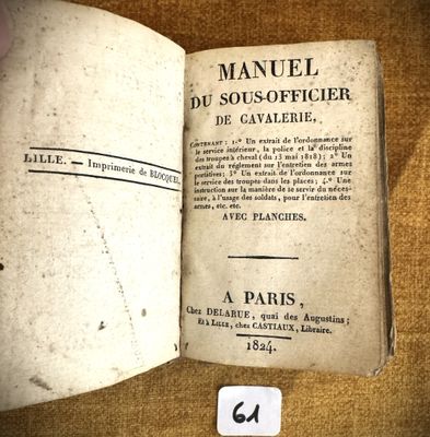 un vieux livre ouvert sur une table, sur lequel est collé un autocollant