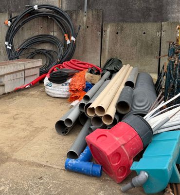 many different types of pipes and hoses on the ground