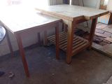 une table en bois avec une étagère en bois en dessous, dans une pièce