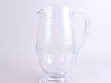 a clear glass pitcher with a handle on a white surface