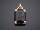 a gold and black onyxite pendant with an image of a woman