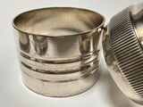 a silver cup sitting on a table next to a silver cup