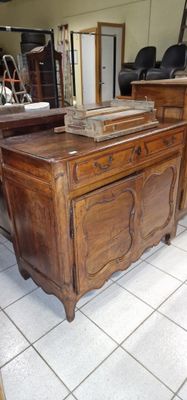 une commode en bois surmontée d'un miroir, dans une pièce