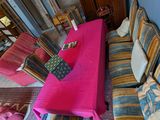un salon avec des canapés et une table recouverte d'une nappe rose