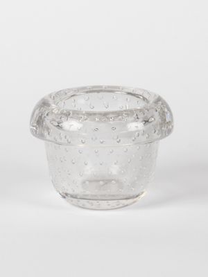 un saladier en verre transparent rempli d'eau et de bulles, posé sur une surface blanche