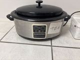a crock pot sitting on the floor next to a container