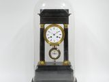 une horloge sous un dôme en verre, sur fond blanc