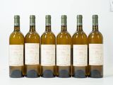 six bouteilles de vin sont alignées sur une surface blanche
