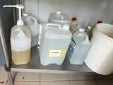a metal shelf with a lot of bottles and a bucket on it