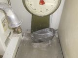 une balance métallique posée sur une boîte métallique