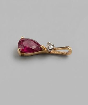 Un rubis poire serti en pendentif or 18 k, surmonté d'un pet…