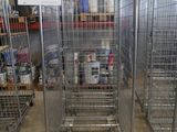 Plusieurs cages métalliques sont empilées les unes sur les autres dans un entrepôt