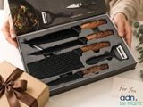a woman holding a box with a set of knives in it