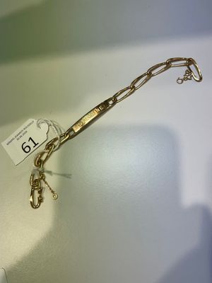 un bracelet en or auquel est attachée une chaîne