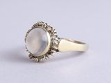 un gros plan sur une bague en or sertie d'une pierre blanche