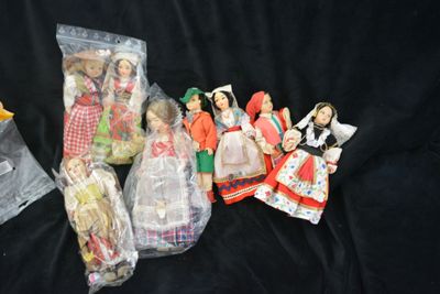 a lot of dolls in plastic bags on a black surface