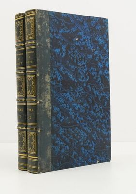 un livre bleu et noir avec des bordures dorées sur une couverture blanche