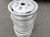a stack of white rims on the ground next to a blue truck