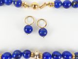 a close up of a necklace and earring set with blue beads