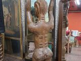 une statue représentant un homme tenant un bol sur la tête