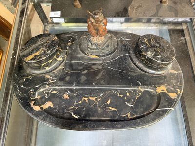 une vitrine en verre posée sur une table en marbre noir sur laquelle se trouve une statue