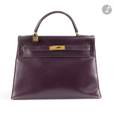 un sac à main en cuir violet avec des finitions dorées sur la poignée