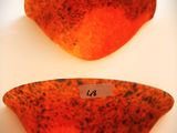 deux morceaux de verre orange et noir posés sur une surface blanche