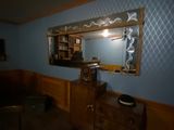 a mirror on the wall above a dresser in a room
