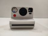 a polaroid camera sitting on top of a white box