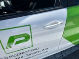 a green and white car parked in a parking lot