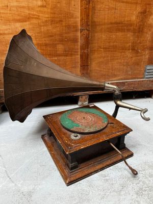 an old gramphone sitting on top of a wooden table next to a wall