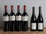 six bouteilles de vin rouge sont alignées sur une table en bois