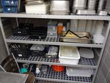 many plates and pans on the shelves in the kitchen