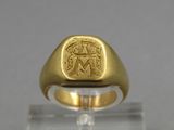 a close up of a gold ring with an image of a man and woman on it