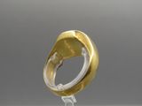 a close up of a gold ring on a clear stand