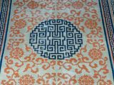 un tapis oriental orange et bleu posé sur un parquet