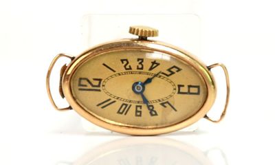 une petite horloge en or dont le cadran est orné de chiffres romains