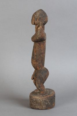 statue d'une femme debout sur un rocher, les mains sur les hanches