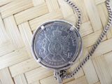 a silver coin with a chain around it on a table