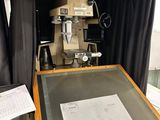 une table sur laquelle est dessiné un motif, avec une machine en arrière-plan