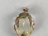 a close up of a pendant with a faceted yellow quartz stone