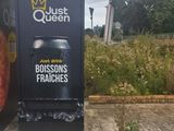 a sign on the side of a building that says just queen