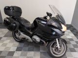 Une moto BMW garée sur un sol à damier dans un garage