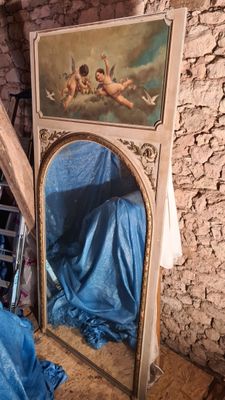 un tableau accroché au mur au-dessus d'un miroir dans une pièce