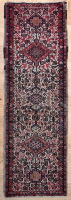 un gros plan d'un tapis rouge et noir posé sur un parquet