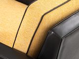 the back of a black leather couch with a yellow cushion