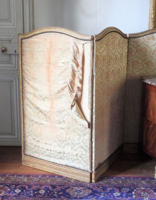 une chambre avec un lit, une commode et un miroir