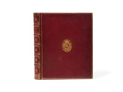 un vieux livre rouge orné d'un médaillon doré sur la couverture